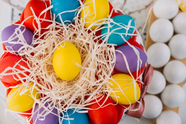 An elevated view of colorful easter eggs on shredded paper