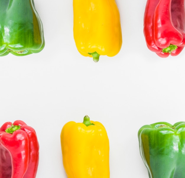 Elevated view of colorful fresh bell peppers on white backdrop