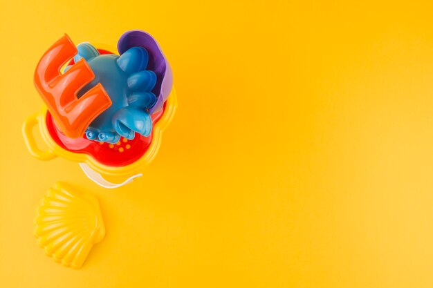 An elevated view of colorful plastic toys on yellow background