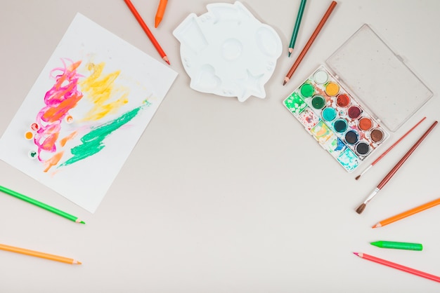 Elevated view of drawing accessories arranged over grey backdrop