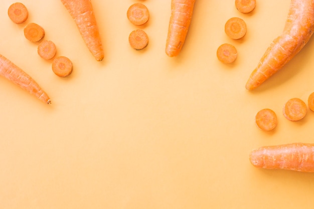 Free photo elevated view of fresh carrots on orange backdrop