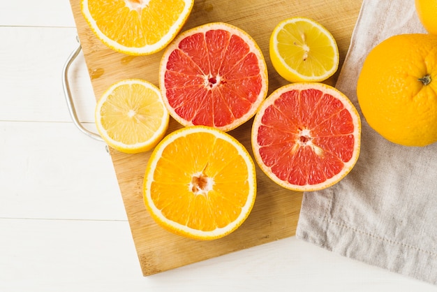 Free photo elevated view of fresh citrus fruits on chopping board