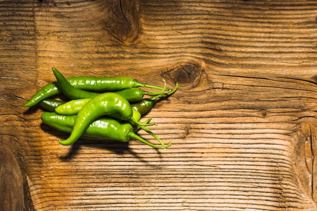 Free Photo elevated view of fresh green chili peppers on wooden surface