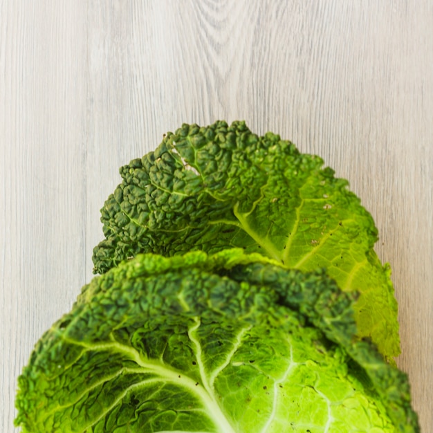 Elevated view of fresh green chinese cabbage leaves on wooden surface