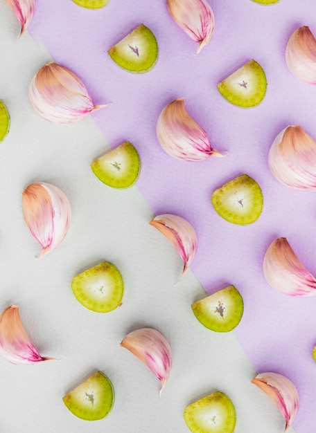 Free Photo elevated view of garlic cloves and sliced chinese kale on dual colored background