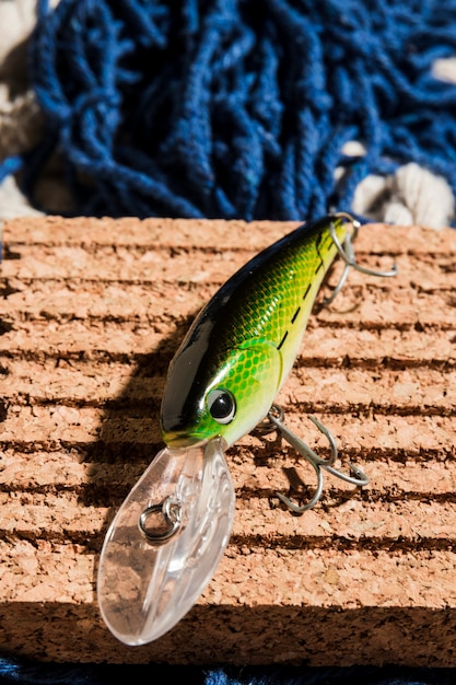 An elevated view of green fishing bait on cork board