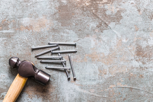 Free Photo elevated view of hammer and nails on old wooden desk