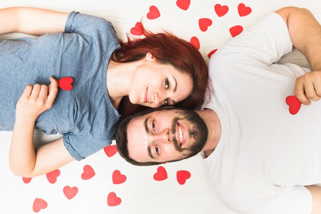 Elevated view of happy couple with red hearts on floor