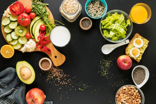 Elevated view of ingredients; dryfruits and vegetables on black background