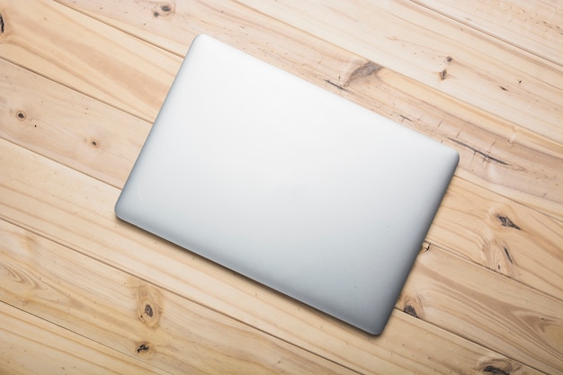 Free photo elevated view of a laptop on wooden plank