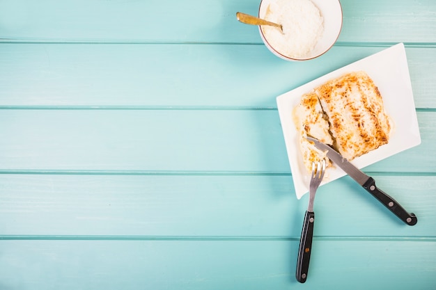 Elevated view of lasagne with fork and knife