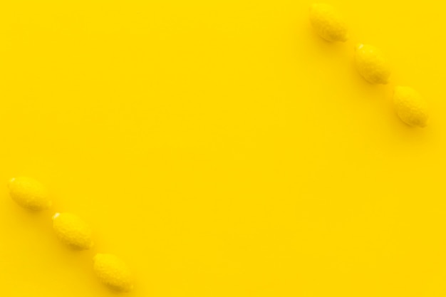 Free Photo elevated view of lemon candies on yellow backdrop