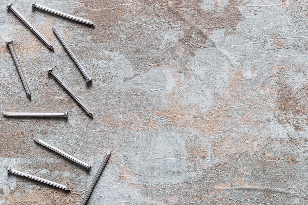 Free photo elevated view of nails on rusty wooden background