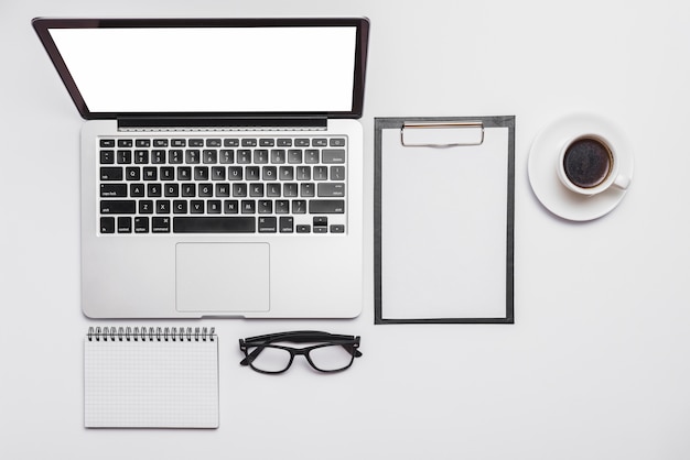 Elevated view of office desk and open laptop and coffee cup