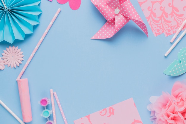 Elevated view of origami crafts art and straw on blue background