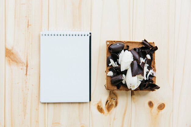 Free Photo elevated view of pastry near blank notepad on wooden surface