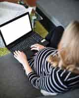 Free photo elevated view of a pregnant woman using laptop with blank white screen