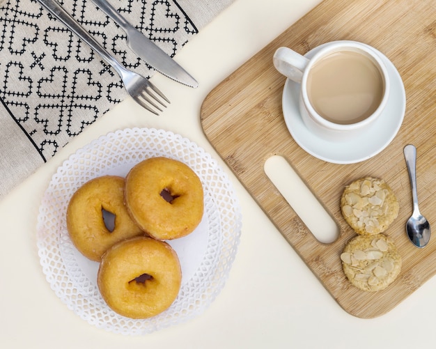 Elevated view of tea with cookies and donuts