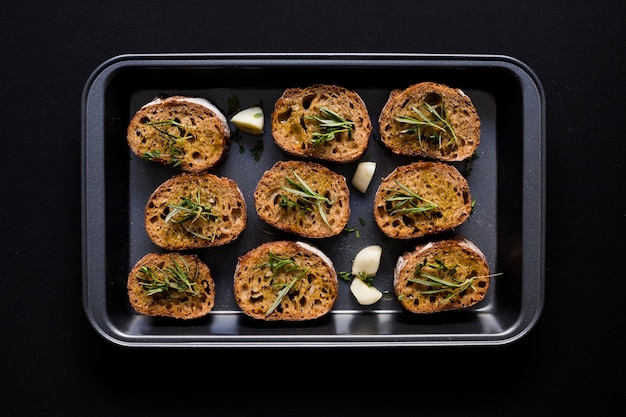 An elevated view of toast bread in the baking tray against black background