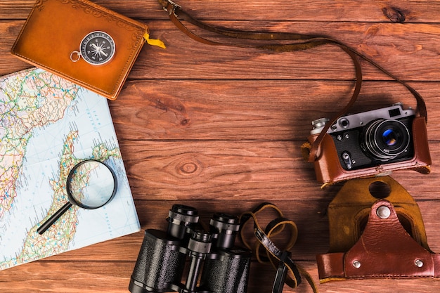 Free photo elevated view of travelling equipments on wooden table