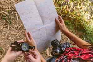 Free photo elevated view of two women holding compass and map