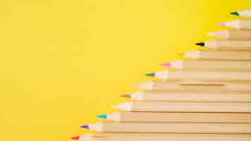 Free photo elevated view of various colorful pencils on yellow background