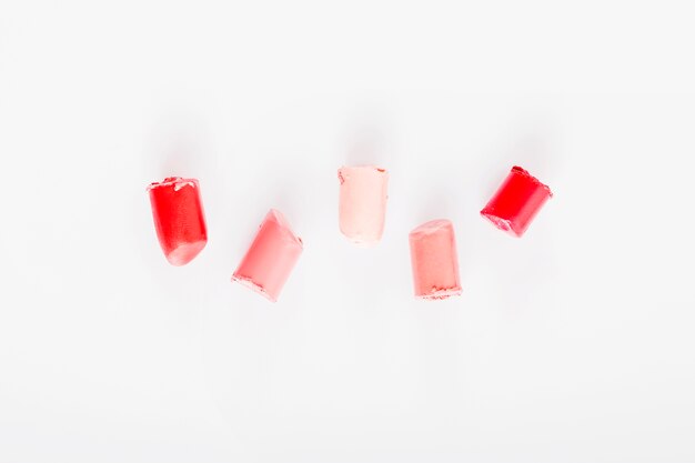 Elevated view of various lipsticks on white background