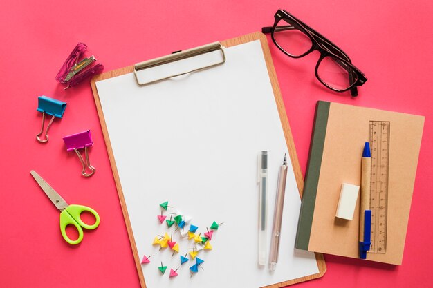 Elevated view of various stationeries on pink background