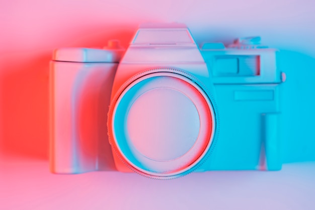 Elevated view of vintage camera on pick surface with blue light and shadow