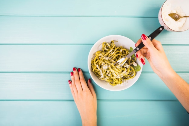 Elevated view of a woman's hand eating spaghetti