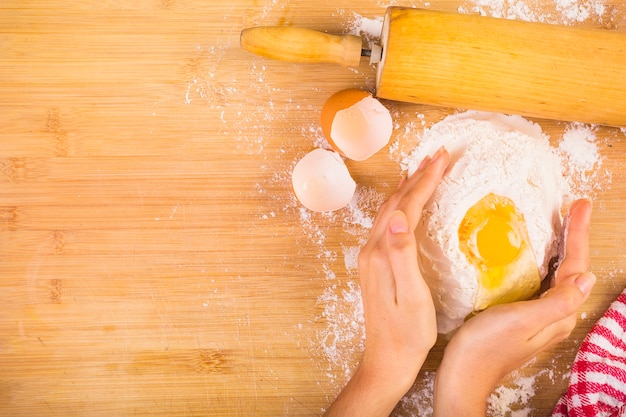 Free photo elevated view of woman's hand mixing flour with egg