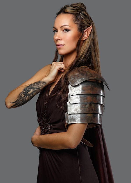 Free Photo elf woman in armour with tattoo on her hand. isolated on a grey background.