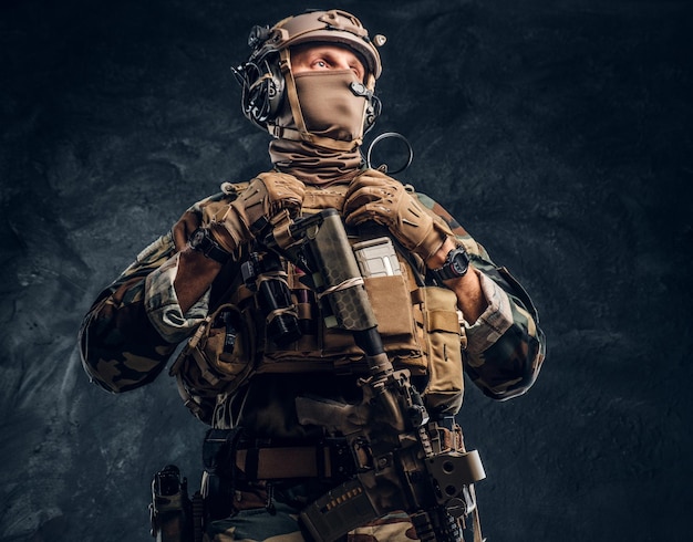 Free photo elite unit, special forces soldier in camouflage uniform. studio photo against a dark textured wall