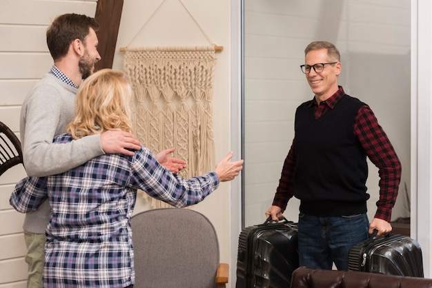 Free photo embraced mother and son with father holding suitcases