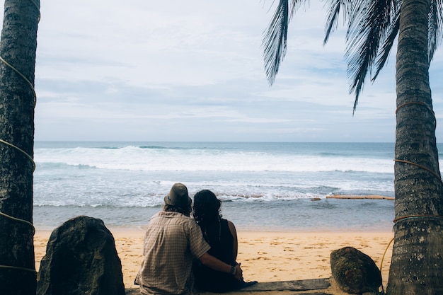 Free Photo embracing couple looking at ocean