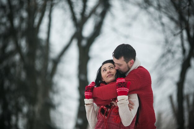 "Embracing couple in winter forest"