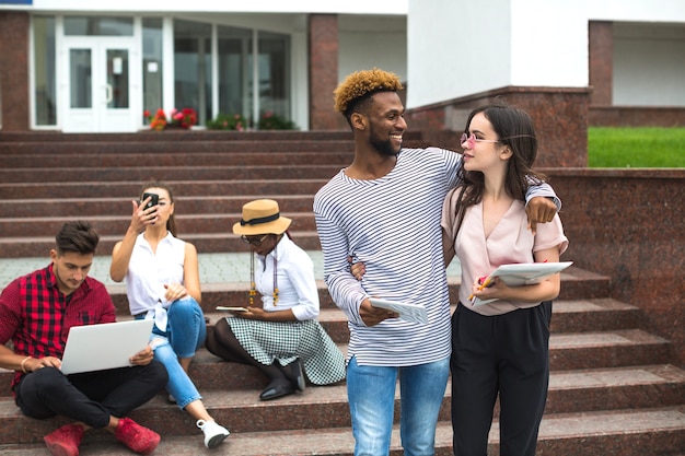 Embracing friends on stairs of university