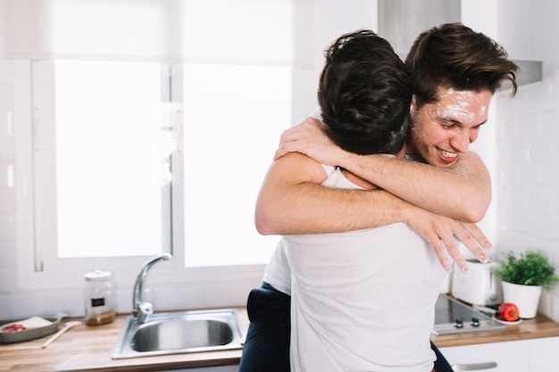 Embracing gay couple in kitchen