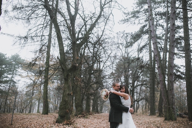 Free Photo embracing newlyweds in leafless forest