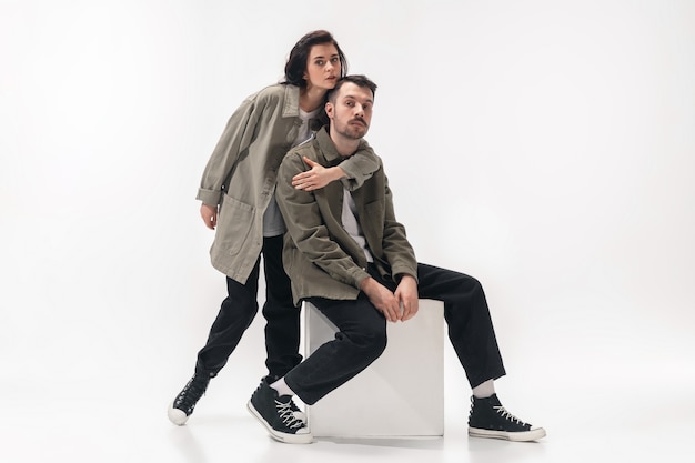 Free Photo embracing. trendy fashionable couple isolated on white studio background. caucasian woman and man posing in basic minimal stylish clothes. concept of relations, fashion, beauty, love. copyspace.