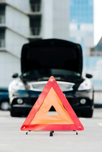 Free photo emergency sign with black car in background