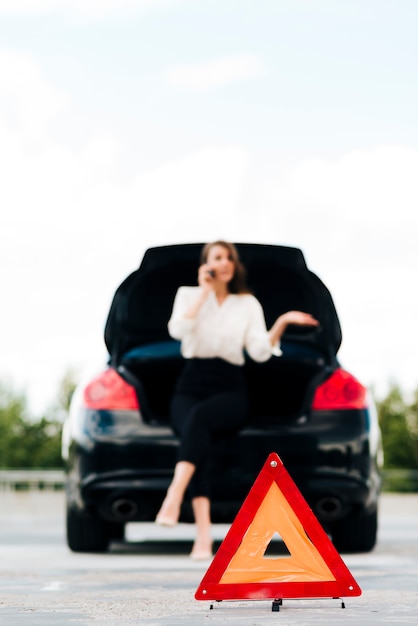 Free photo emergency sign and woman talking on phone