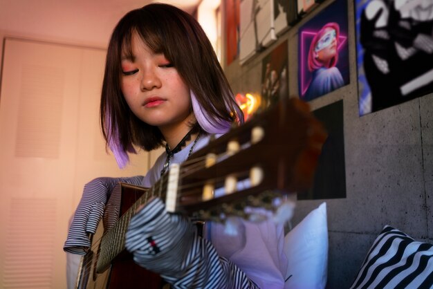 Emo girl holding guitar side view