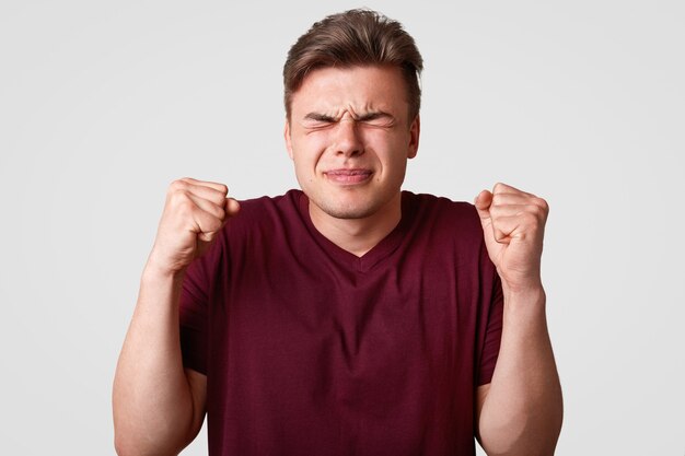 Emotional Caucasian young male with trendy hairstyle