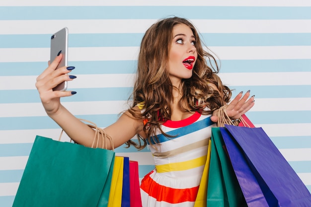 Free Photo emotional female shopaholic making selfie. enchanting white girl fooling around after shopping.