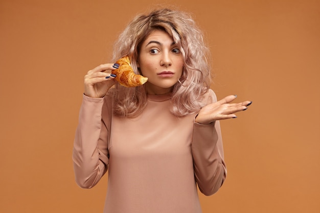 Free photo emotional funny surprised young woman with pinkish hair expressing astonishment opening eyes widely, gesturing helplessly, being at loss while having phone conversation