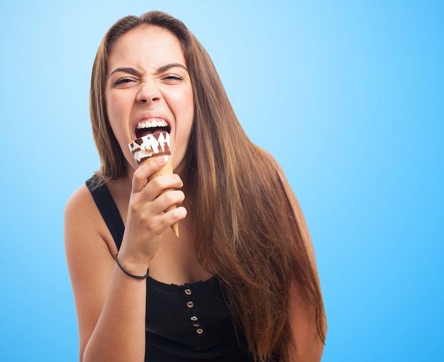 Emotional girl biting ice cream.