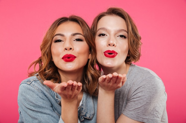 Emotional ladies friends blowing kisses.