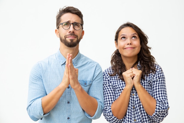 Emotional young couple praying together