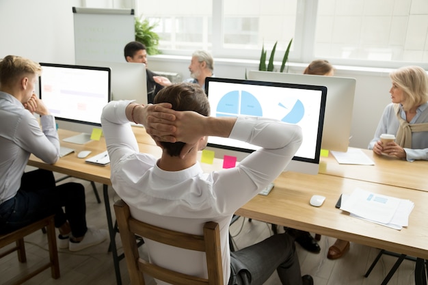 Free photo employee analyzing statistics report sharing office desk with diverse colleagues